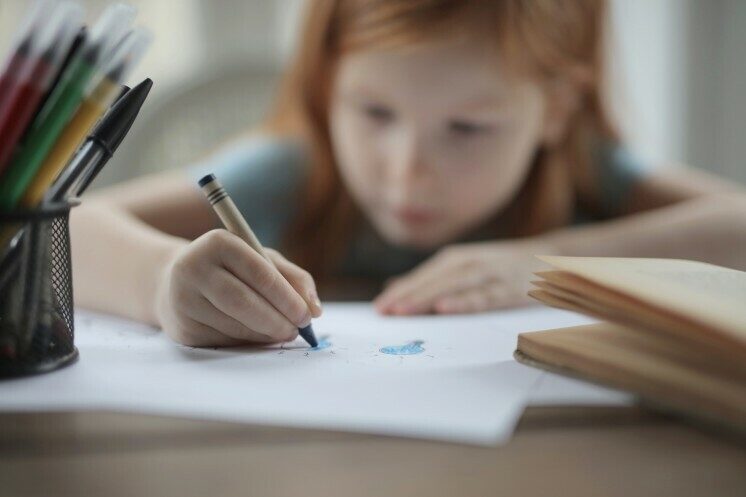 Girl drawing with crayon.