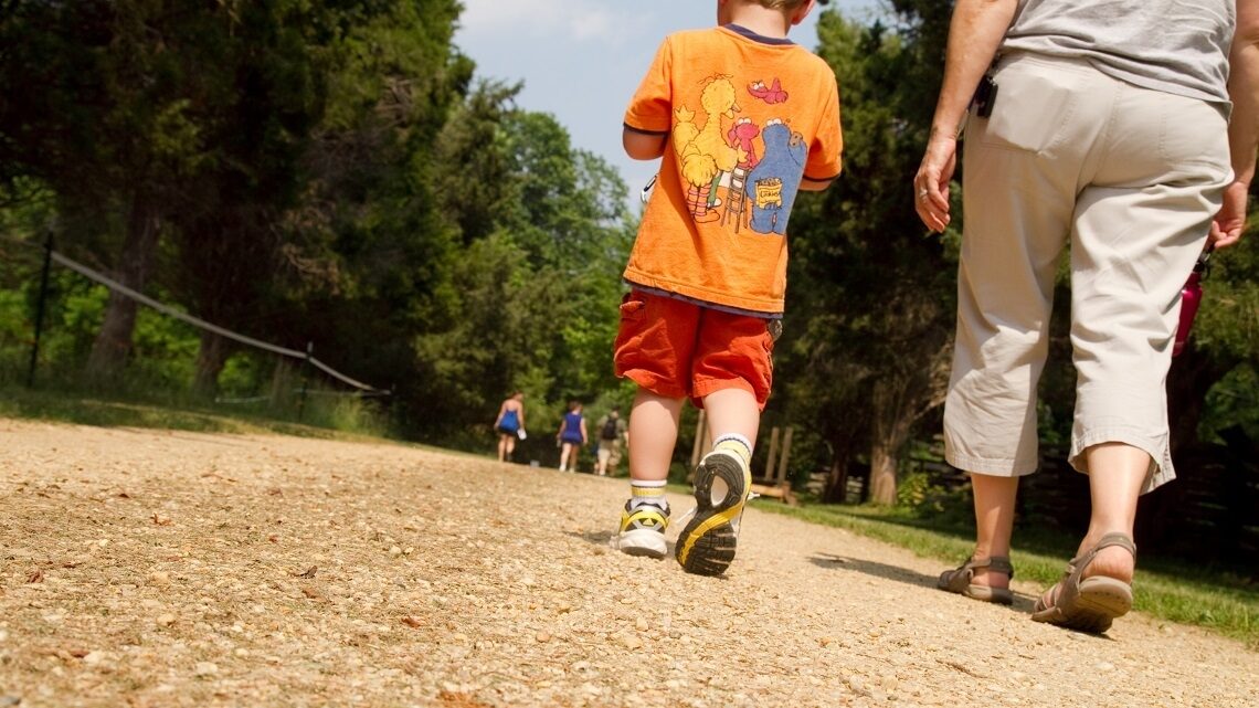 Child and adult walking along a path