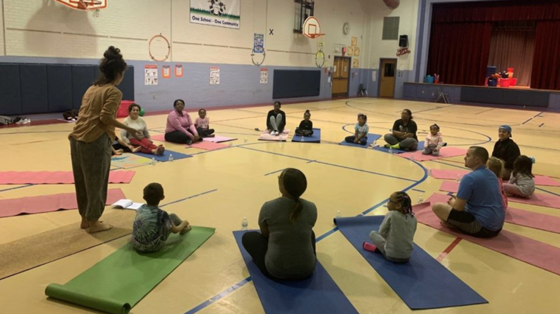 Students and family practice yoga together at school.