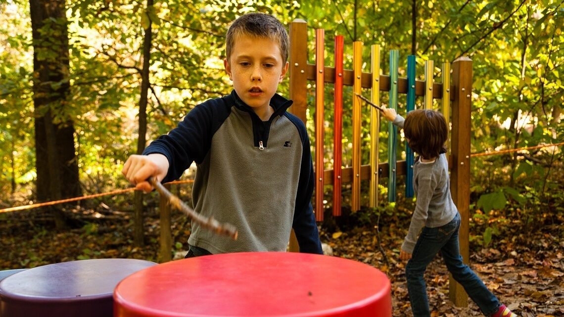Students playing with musical instruments in the woods