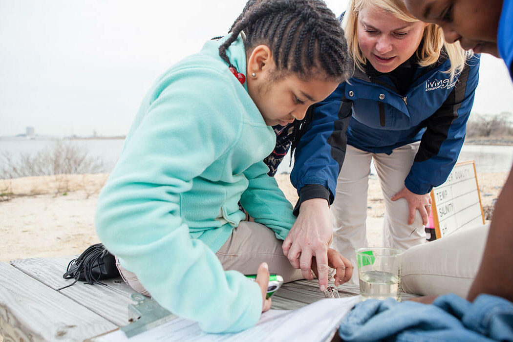 Educator and students work on a beach