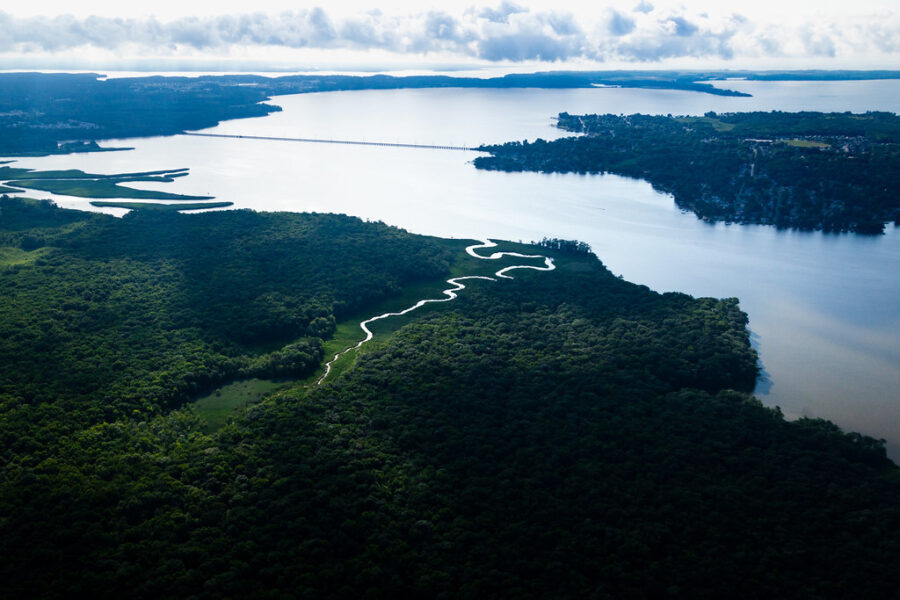 An aerial view of the Bird River, bordered by thick forest, entering the Gunpowder River in Baltimore County, Maryland.