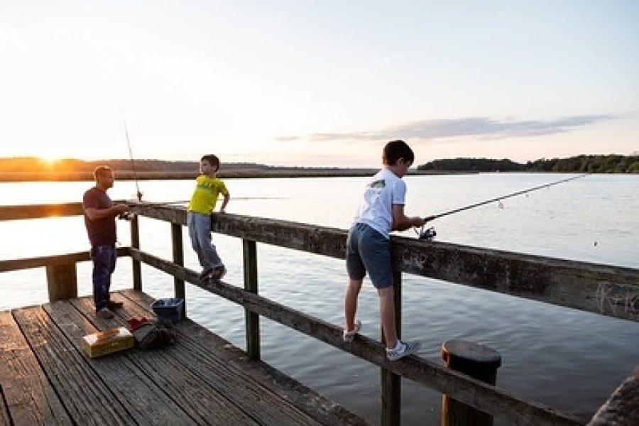 A man and two boys fishing off pier at public access site